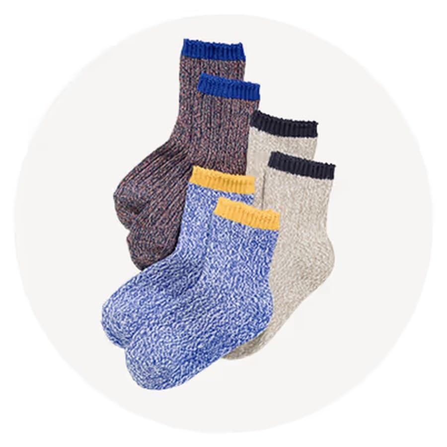 Three pairs of marled knit crew socks—blue with yellow cuff, beige with navy cuff, and brown with blue cuff—stacked on a Old Navy sale